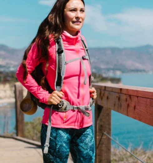 Windbreaker - Woman in Pink Zip Up Jacket and Blue Denim Jeans Standing on Brown Wooden Bridge during