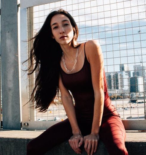 Rompers - Beautiful fashion model sitting on concrete ledge with city view