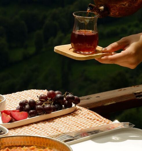 Meals - Woman Hands with Tea over Table with Breakfast