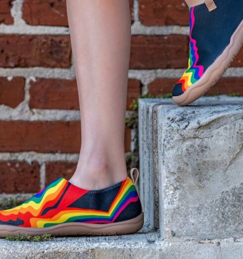 Stilettos - A woman in colorful shoes standing on a brick wall