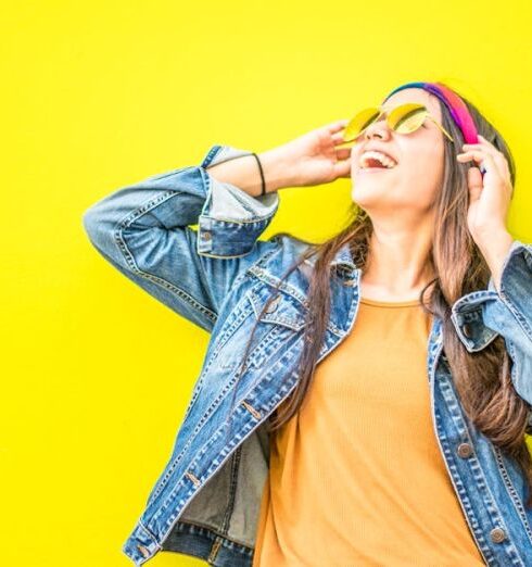 Jackets - Smiling Woman Looking Upright Standing Against Yellow Wall