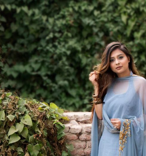 Dress - Woman in Blue Dress Standing Near Brown Concrete Bricks