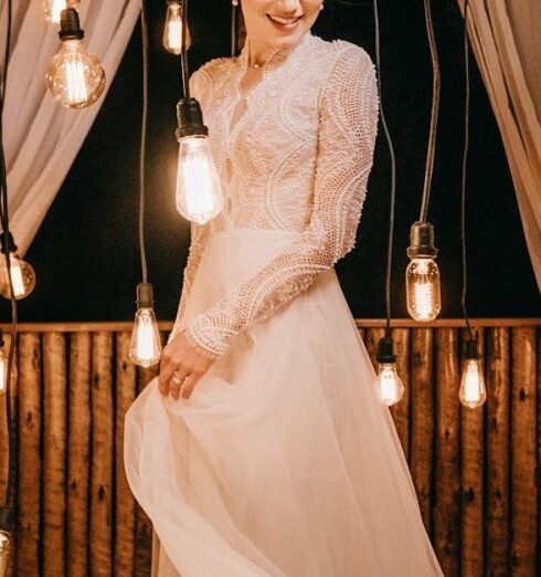 Gown - Woman Standing Beside Hanging Light Bulbs