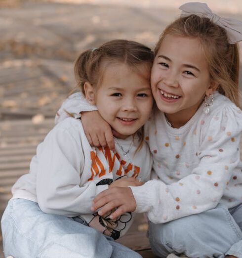 Sweaters - Two little girls sitting on a bench in the woods