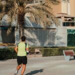 Joggers - Morning waterfront promenade with palm trees and jogger on modern marina walkway