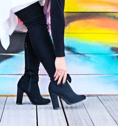 Boots - Photo of Woman Touching Right Heeled Shoe Beside Wall