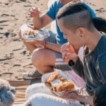 Snacks For Kids - Family Sitting on a Log while Eating Snacks