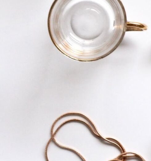 Necklace - Gold-colored Heart Pendant Necklace Beside Two Glass Mugs on Table