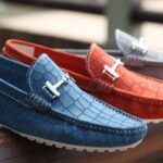 Footwear - Selective Focus Photography of Three Unpaired Red, Blue, and Gray Leather Horsebit Loafers