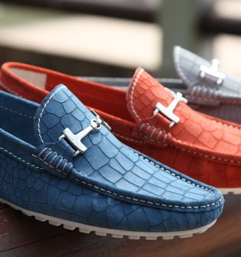 Footwear - Selective Focus Photography of Three Unpaired Red, Blue, and Gray Leather Horsebit Loafers