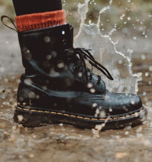 Boots - Water Splashing From A Person In Black Workers Boots Stepping On Wet Pavement