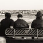 Jackets - Three people sitting on a bench by the water