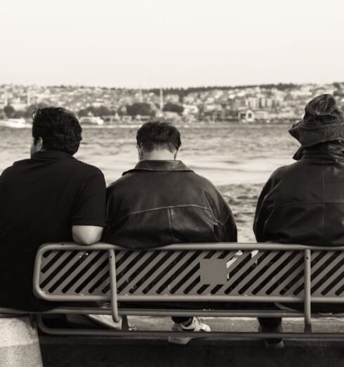 Jackets - Three people sitting on a bench by the water