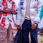 Jackets - Two young men standing on a hill with a camera