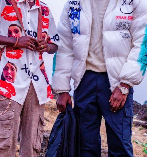 Jackets - Two young men standing on a hill with a camera