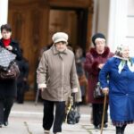 Coats - Women walk past a church in the old town of moscow