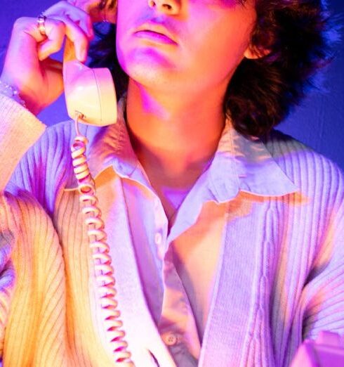 Cardigans - A young man sitting on a chair talking on a phone