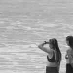 Bikinis - Women and Surfboard on Beach