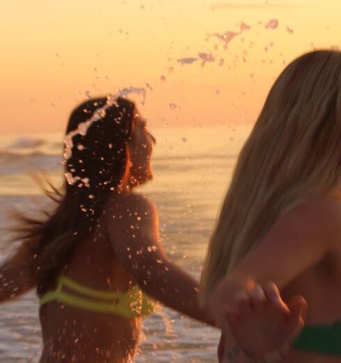 Bikinis - Women in Bikinis Holding Hands and Running on Sea Shore Together