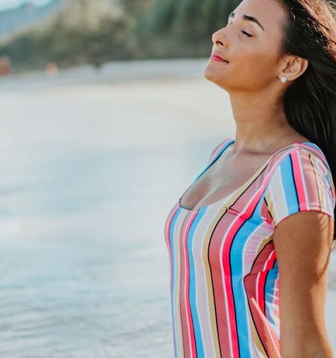 Swimsuit - Woman in a Multicolored Swimsuit Sitting on Beach