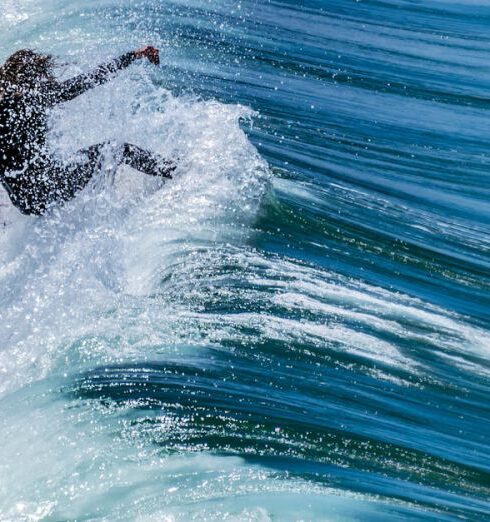 Swim Romper - A surfer is riding a wave in the ocean