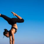 Wellness - Woman With Arms Outstretched Against Blue Sky