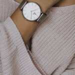 Necklace - Woman Wearing Beige Crochet Sweater and Round White Analog Watch Closeup Photo