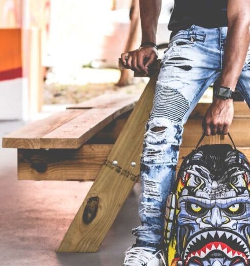 Jeans - Man Wearing Distressed Denim Pants Holding Multicolored Backpack