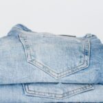 Jeans - Pile of denim pants of different shades of blue placed on white shelf