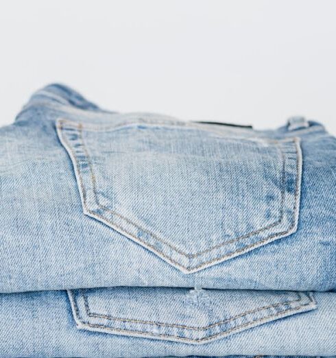 Jeans - Pile of denim pants of different shades of blue placed on white shelf