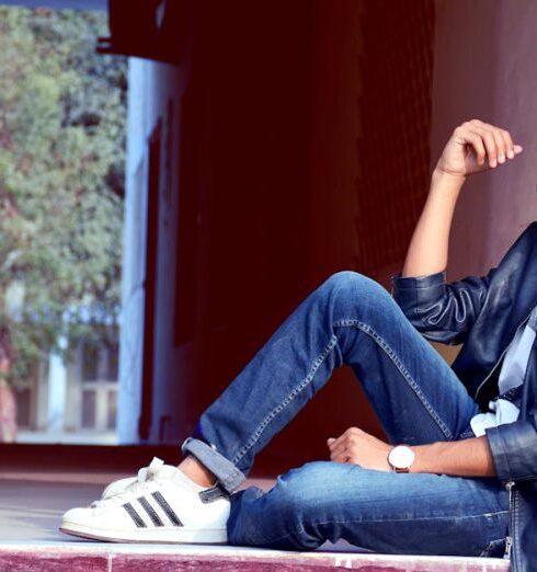 Jeans - Man Wearing Black Leather Jacket and Blue Jeans Sitting on Floor