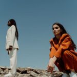 Blazers - A Woman in Orange Blazer and Pants Sitting on the Rock