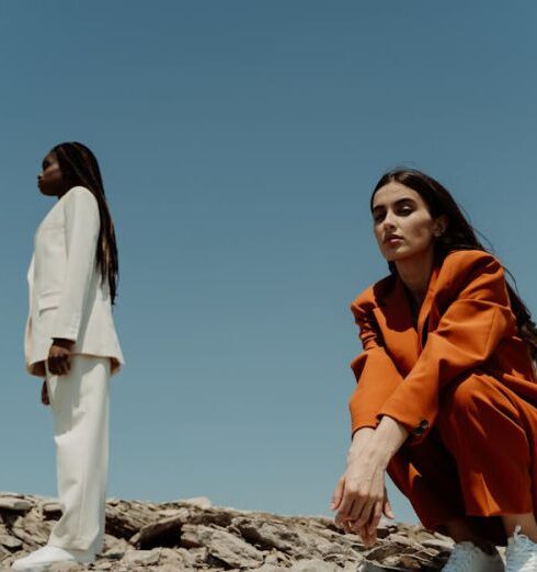 Blazers - A Woman in Orange Blazer and Pants Sitting on the Rock