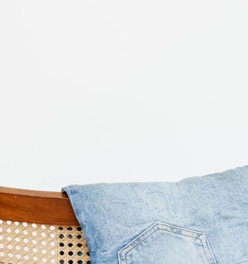 Jeans - Trendy blue jeans put on back of wooden chair near empty white wall