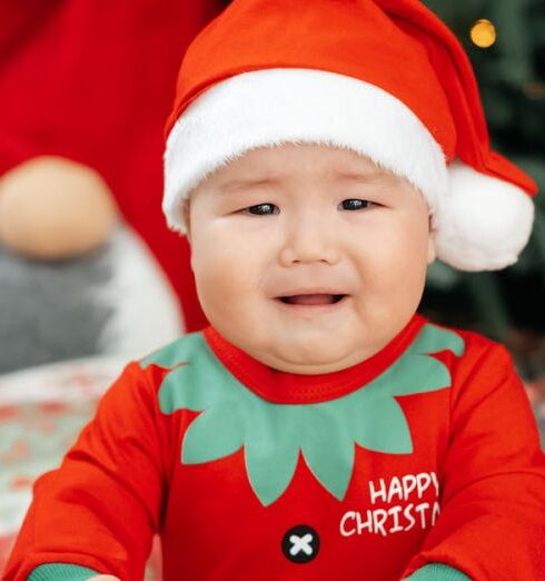 Rompers - A baby in a santa outfit sitting on the floor