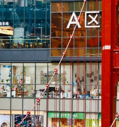 Fashion Stores - People Walking on a Red Pedestrian Footbridge in a Shopping Mall