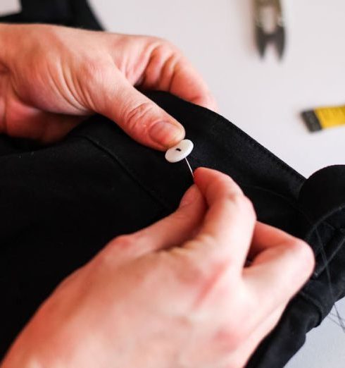 Custom Tailoring - A Person Sewing a Button on a Cloth