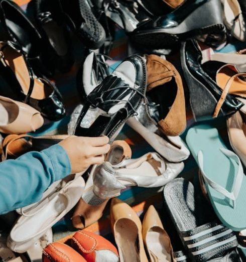 Affordable Fashion - Hand Picking Up Shoes at Market