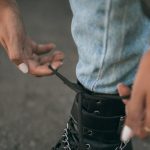 Fashion Items - Close-up of Woman Tying Her Boot