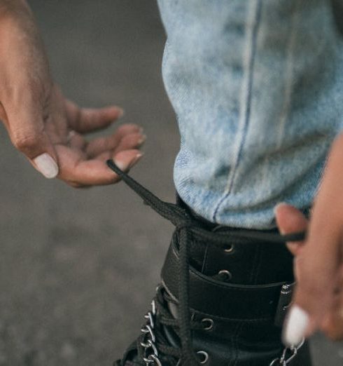 Fashion Items - Close-up of Woman Tying Her Boot