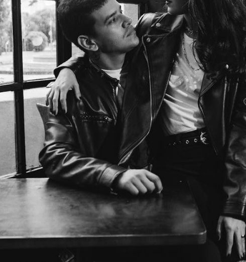 Vintage Jackets - Couple in Leather Jackets Sitting by Table in Black and White