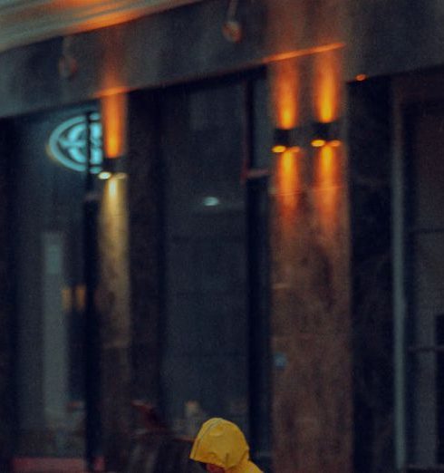 Fashion Stores - A Child in a Yellow Raincoat on a Wet Sidewalk