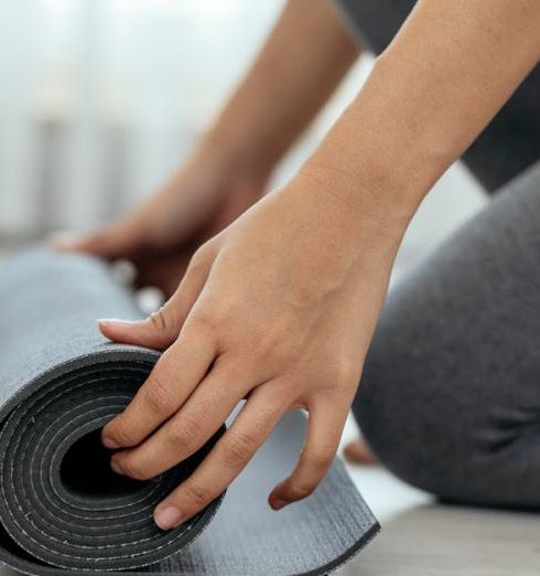 Activewear - Crop woman unrolling mat in daylight