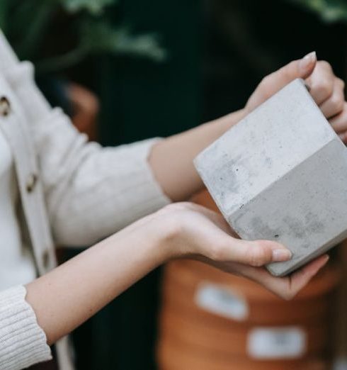 Home Goods - Person Holding a Matte Gray Ceramic Pot