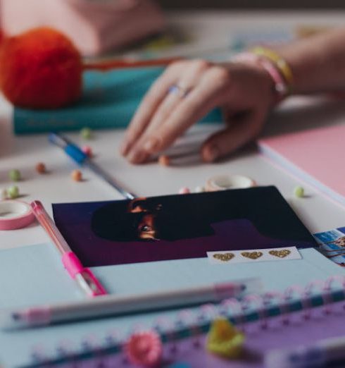 DIY Projects - Woman Hands on Table with Colorful Notebooks and Pens