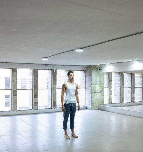 Wall Mirrors - Man in White Tank Top Standing on a Studio