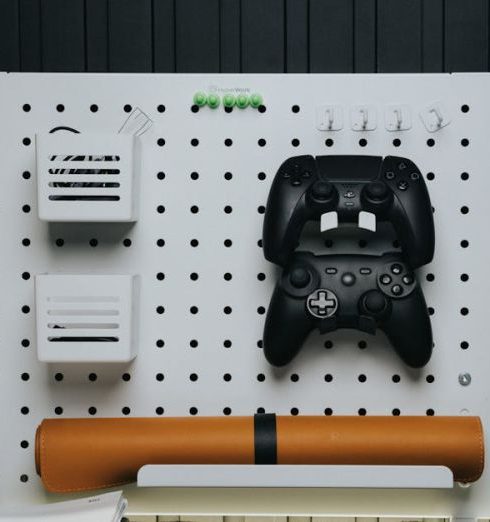 Home Accessories - A Board with Game Controllers Standing on the Desk