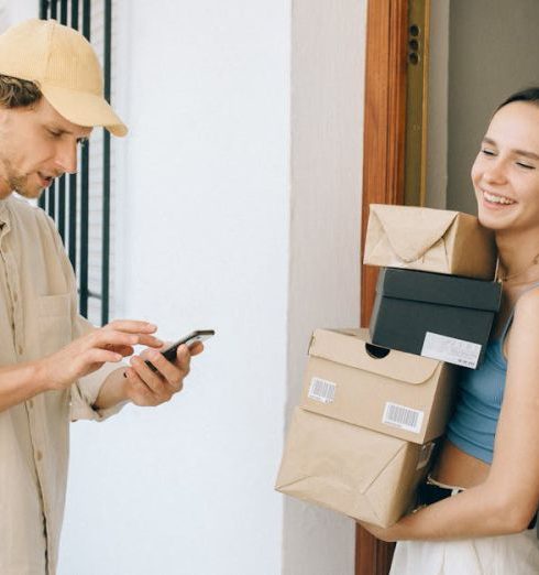 Subscription Boxes - Woman in Blue Tank Top Carrying Brown Boxes