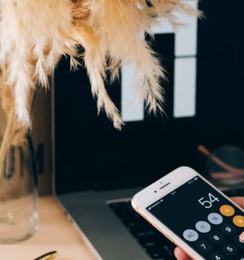 Smartphone Deals - Woman Using Calculator in Smartphone in Office