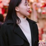 Gift Shopping - Young Woman in a Black Coat Over a White Sweater Doing Christmas Shopping